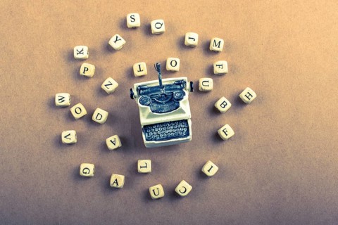 Letter cubes of made of wood around model typewritter