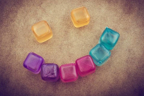 Fake colorful ice cubes on a brown background