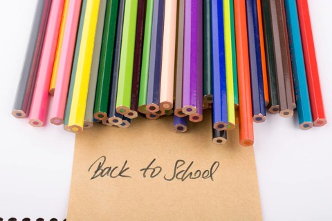 Color pencils and back to school title on a notebook