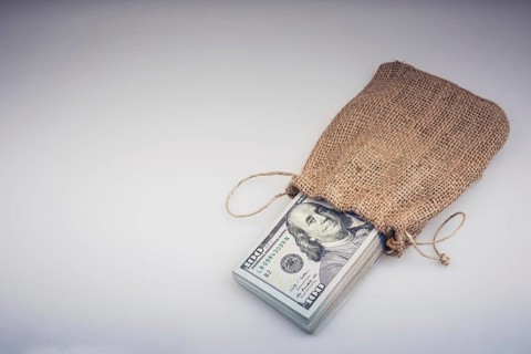 Banknote bundle of US dollarin a sack on a white background