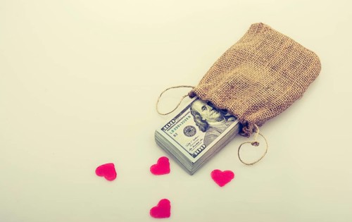 Red hearts and banknote bundle of US dollarin a sack