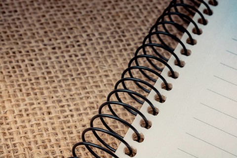 Brown color spiral notebook placed on a canvas background