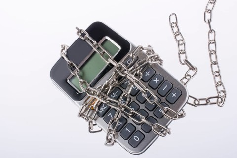 Calculator wrapped in chains on a white background