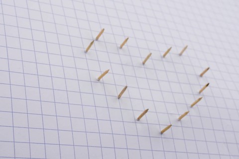 Nails make hole on paper forming a heart shape