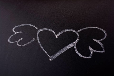 Heart shaped drawing with wings on blackboard