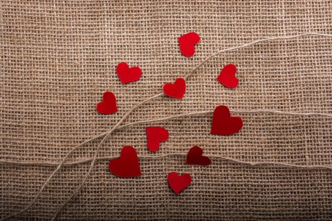 Love concept with heart shaped papers on linen threads