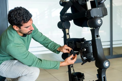 Mechanical exoskeleton engineer checking the mechanisms before the arrival of patients. Physiotherapy in a modern hospital: Robotic skeleton. Physiotherapy Rehabilitation Scientists