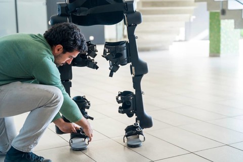 Mechanical exoskeleton engineer checking robot before delivery to customer. Physiotherapy in a modern hospital: Robotic skeleton. Physiotherapy Rehabilitation Scientists