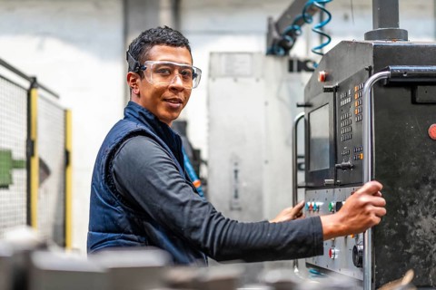 Portrait of Latin industrial worker in the metal industrial factory trade in the numerical control sector