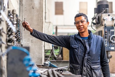 Latino worker in the metal industrial factory trade in the numerical control sector