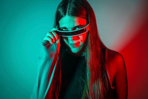 Futuristic studio portrait with neon lights of a sensual transgender person wearing augmented reality googles