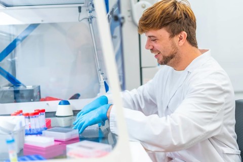 Young scientist working on cells in a cancer research and infectious diseases laboratory