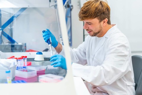 Side view of a young biologist using pipette in a innovative laboratory