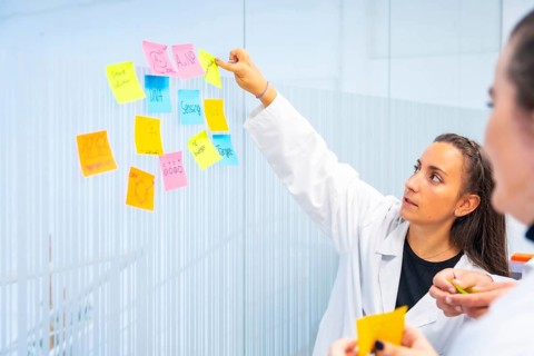Biologist pointing a note during a creative research process in a laboratory