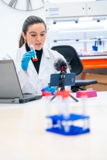 Vertical photo of a scientist recording a scientific video podcast in a lab
