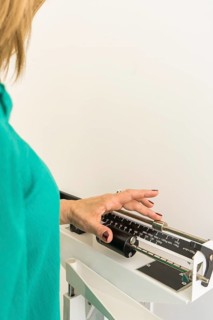 Close-up of woman on weighing scale in nutritionist's office. Vertical Shot