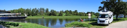 Panoramic photo with a motorhome in the motorhome parking area