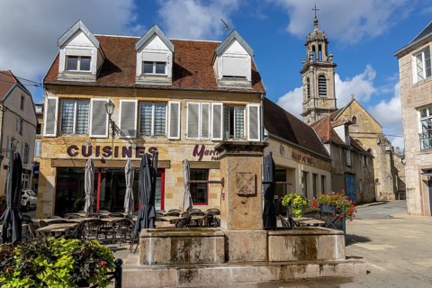 The fountain in Rue Diderot and the church tower in the background Catholic church Eglise Saint Martin