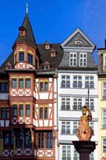 Fountain representing roman goddess Minerva in front of colorful Half-timbered houses in Roemerberg square