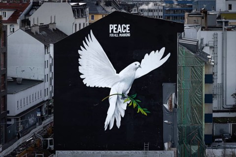 PEACE FOR ALL MANKIND is written above the image of a giant dove of peace on the wall of a house in Frankfurt am Main: a message of peace in the contemporary historical context of the escalated Middle...