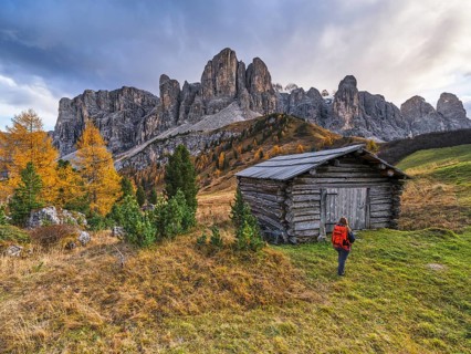 Hiker in front of hut and Sella Group