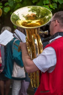 Musician holds his tuba and sheet of music ready to play