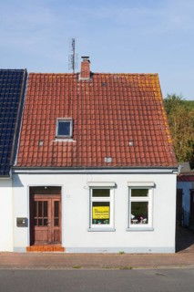 Old house with sign for sale