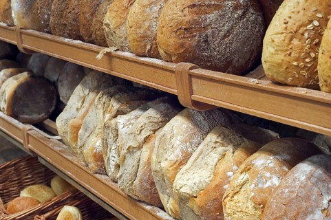 Shelves with loaves of fresh baked bread on display in bakery