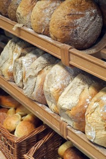 Shelves with loaves of fresh baked bread on display in bakery