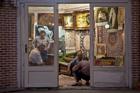 Men selling carpets in carpet store in the old historic bazaar of the city Tabriz