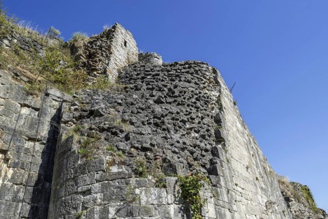 Thick stone wall of medieval castle showing two types of masonry