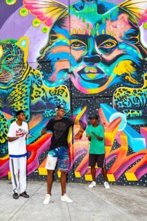Breakdancing in front of graffiti on the wall of a house