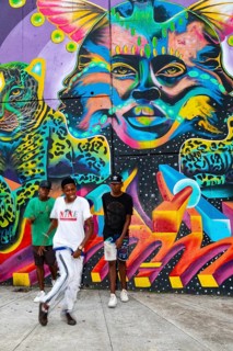 Breakdancing in front of graffiti on the wall of a house
