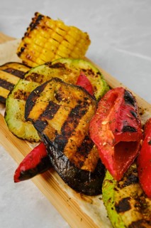 Close up view of grilled vegetables on wooden serving board