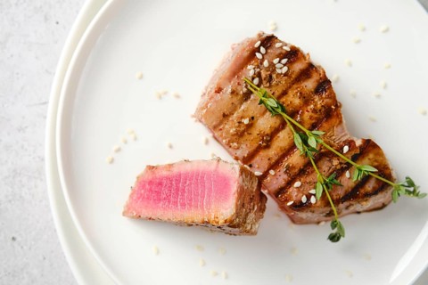 Closeup top view of plate with a portion of grilled tuna steak