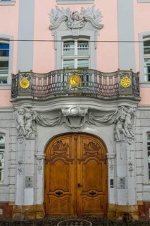 Luxurious entrance door with balcony and figures on the facade