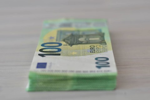 Many one hundred euro notes in a pile on a table