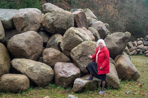 Woman stand at a stone storage in the nature in Fyledalen