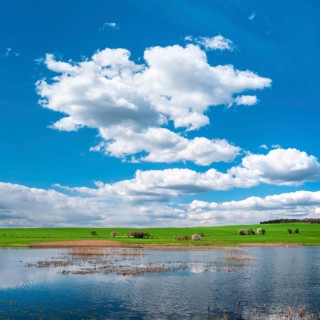 Small lake under blue sky with