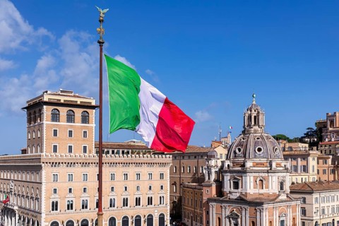 The Italian flag seen in front of the Church of Santa Maria di Loreto al Foro Traiano on the right