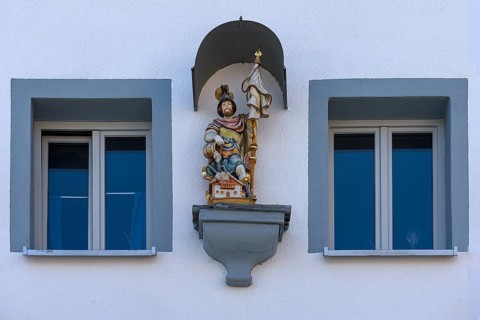 Figure of St Florian under a canopy on a house