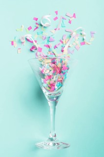 Glass with confetti turquoise background