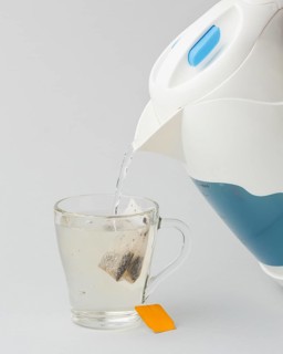 Making tea with hot water from electric kettle
