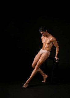 Muscular dancer leaning barre