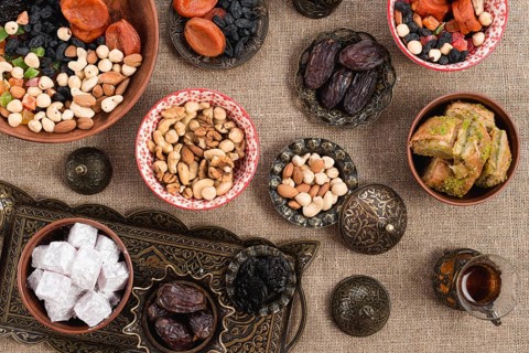 Overhead view turkish tea dates lukum dried fruits nuts jute tablecloth