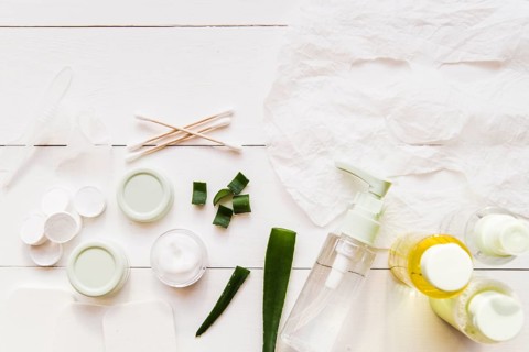Paper sheet face mask cotton swabs moisturizer aloevera white wooden plank