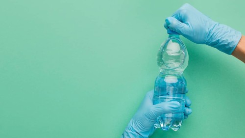 Person wearing gloves opening bottle