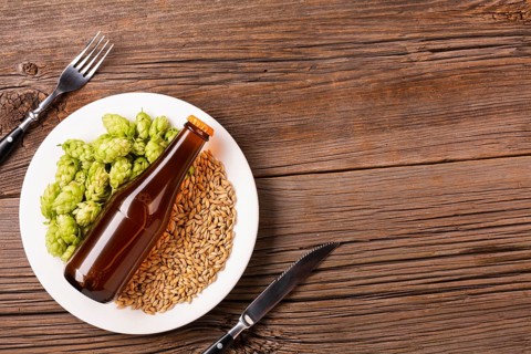 Plate with beer ingredients wooden background