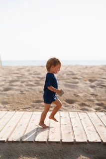 Playful little boy running beach