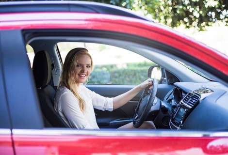 Portrait happy woman sitting inside car